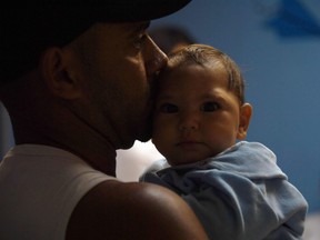 Paulo Sergio (37) holds his six-month-old baby Arthur Meneses as they wait for medical exams at the State Brain Institute (IEC) in Rio de Janeiro, Brazil on January 2, 2017. In B.C. there has been 47 new Zika cases in the past six months.