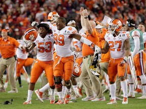 Clemson Tigers players celebrate on the sidelines after their quarterback Deshaun Watson threw the game-winning touchdown in the 35-31 upset win over No. 1-ranked Alabama in the U.S. College Football Playoff National Championship in Tampa, Fla., on Monday.