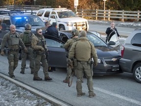 Members of the RCMP emergency response team and Coquitlam RCMP at the scene of what they described as a 'high-risk vehicular takedown' on David Avenue at Oxford Street in Coquitlam on Tuesday. A hostage was rescued by police from the  grey Chevrolet.