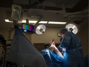 Surgeons remove a cyst from a male patient's knee at the private Cambie Surgery Centre in Vancouver.