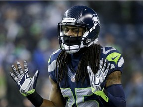 FILE - In this Jan. 10, 2015, file photo, Seattle Seahawks cornerback Richard Sherman gestures during warmups before an NFL divisional playoff football game against the Carolina Panthers in Seattle. Whether by design or coincidence, Aaron Rodgers didn't throw in cornerback Richard Sherman's direction in the teams' first meeting this season.