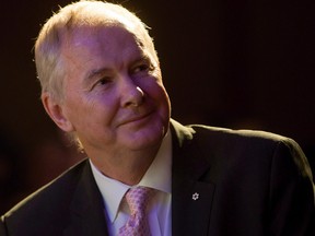 John Furlong, Own The Podium board chairman and former CEO of the Vancouver Olympics, watches a video of 2010 Olympic moments before addressing a Vancouver Board of Trade luncheon in Vancouver, B.C., on Wednesday November 25, 2015. Furlong will be back at the podium for a University of British Columbia fundraising event after the abrupt cancellation of his speech and subsequent apology from the university.