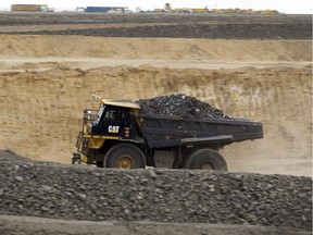 In this July 6, 2012 photo, a truck loaded with coal drives to a process station at Erdenes Tavan Tolgoi, a coal mining company in Tavan Tolgoi, southern Mongolia. Chinese demand for copper and especially coal has propelled the Mongolian economy to one of the world's fastest growing, making some wealthy and driving down poverty in a still poor country, and China wants a larger share of the resources.