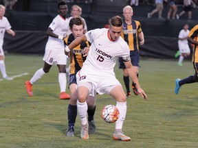 Vancouver Whitecaps draft pick Jakob Nerwinski of UConn holds off a Quinnipiac player an August, 2015 game.