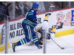 Vancouver Canucks' Nikita Tryamkin, left, of Russia, checks Nashville Predators' Harry Zolnierczyk during the second period of an NHL hockey game in Vancouver, B.C., on Tuesday January 17, 2017.