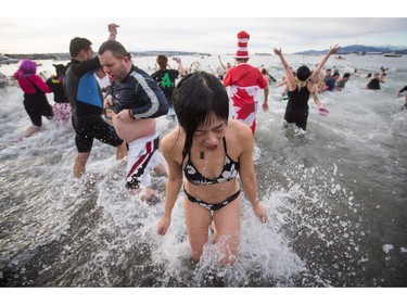 Participants run in and out of the frigid waters of English Bay during the Polar Bear Swim in Vancouver, B.C., on Sunday, January 1, 2017. The event, hosted by the Vancouver Polar Bear Swim Club, was first held on new year's day in 1920.
