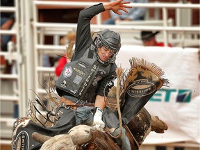 Ty Pozzobon of Merritt, British Colombia, rides a bull called Gold Spring in the bull riding event during the Calgary Stampede rodeo in Calgary, Alta. on Thursday July 10, 2014.