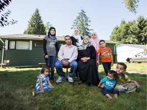 A family portrait of the Sua'ifan family in front of their home in Surrey, B.C.