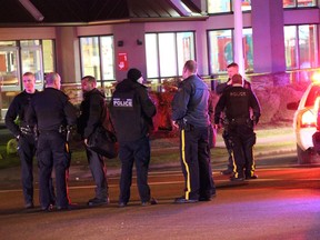 Police gather in Surrey after Karanpartap Waraich, 22, was fatally shot on Monday, Jan. 23, slamming his vehicle into a McDonald's sign.