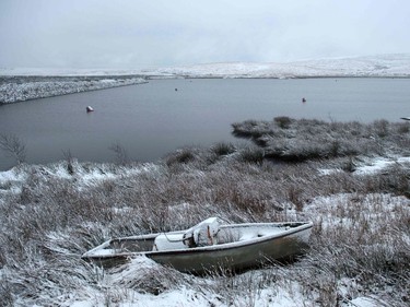 A derelict boat lies covered in snow adjacent to Redbrook reservoir near the village of Marsden in northern England, on January 12, 2017. Heathrow has cancelled 80 flights due Thursday on forecasts of heavy snow, Britain's biggest airport announced. Heavy snow was lying across Scotland, Northern Ireland and parts of England by Thursday morning.