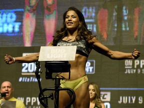 Mixed martial artist Julianna Pena poses on the scale during her weigh-in for UFC 200 at T-Mobile Arena on July 8 in Las Vegas, Nev.