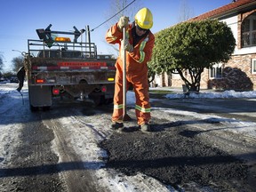 Vancouver city crews fill one of the many potholes that have appeared across the city due to numerous freezing and thawing cycles in the weather.