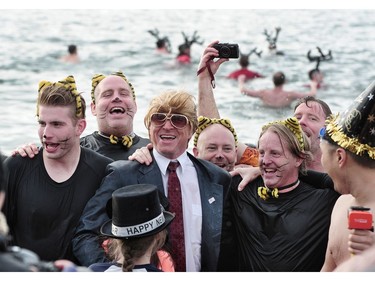 New Years' day revellers enjoy the annual Polar Bear Swim at English Bay in Vancouver, BC., January 1, 2017. After the initial swim in 1920 it reached a record attendance of 2,500 registered swimmers in 2014.