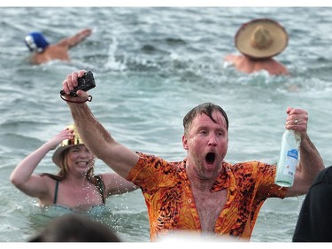 New Years' day revellers enjoy the annual Polar Bear Swim at English Bay in Vancouver, BC., January 1, 2017. After the initial swim in 1920 it reached a record attendance of 2,500 registered swimmers in 2014.