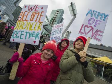 Maizie, 6, Poppy, 8,  and Sabine 8 carry signs as thousands attend the Women's March in Vancouver, B.C., January 21, 2017.