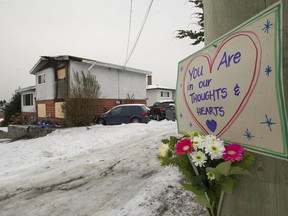 Signs and flowers are placed around a house on Nootka Street after a fire claimed the life of a two-year-old Vancouver girl.