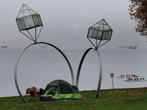 A homeless person pitched a tent at English Bay, under the sculpture ‘Engagement,’ during a conference of international housing experts in Vancouver last October.