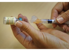 A nurse prepares a vaccine for shingles in Vancouver.
