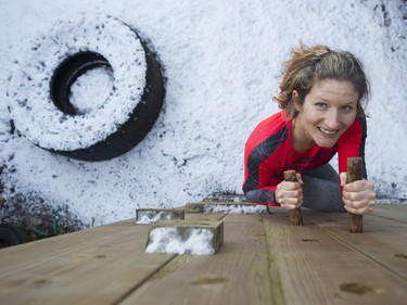 Allison Tai climbs a wall as part of the obstacle course she has built in her east Vancouver backyard.
