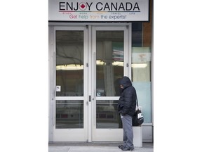 One person at Canada's 19th national Metropolis conference referred to key settlement-sector colleagues as "activists with pensions." Photo: Man in downtown Vancouver walks past a poster for a college that caters to international students. Gerry Kahrmann / PNG