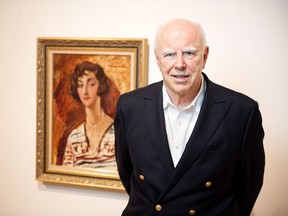 Michael Audain poses with a 1927 portrait of his mother, Madeline Stulik, by the English painter Augustus John.