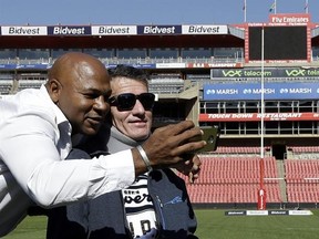 FILE - In this Wednesday, June 24, 2015 file photo, former rugby players Chester Williams, left, with teammate Joost van der Westhuizen, right, take a selfie during their 1995 Rugby World Cup-winning team reunion at Ellis Park stadium in Johannesburg, South Africa. Joost van der Westhuizen, who won the 1995 World Cup with South Africa as Nelson Mandela looked on, has died after a six-year-battle with motor neuron disease. He was 45. South Africa Rugby announced the death Monday, Feb. 6, 2017. (A