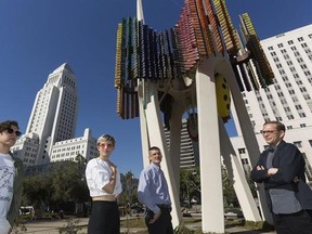 In this Wednesday, Feb. 1, 2017, photo members of the Triforium project, from left, Jona Bechtolt, Claire Evans, Tom Carroll, and Tanner Blackman, pose for a photo with Joseph L. Young&#039;s Triforium a &ampquot;polyphonoptic&ampquot; public sculpture at the Fletcher Bowron Square downtown Los Angeles. For 40 years Joseph Young festooned public buildings, open spaces and private places across his adopted city of Los Angeles with dozens of brilliant, larger-than-life artworks. Mocked for 42 years as pointless and si