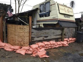 Sandbags border a trailer at Driftwood Mobile Home Park on the Tuolumne river Friday, Feb. 17, 2017, in Modesto, Calif. Fire crews visited the park this morning to ask people to voluntarily evacuate because of rising water. (Joan Barnett Lee /The Modesto Bee via AP)