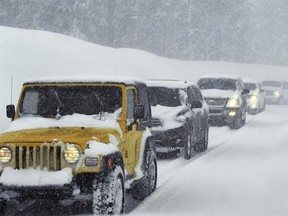 Vehicles make their way down the Mt. Rose Highway near Reno, Nev., Tuesday, Feb. 21, 2017. One of the strongest in a series of winter-long storms pummeled the Sierra Nevada with another 3 feet of snow on Tuesday, dumping triggering an avalanche that buried a major highway near Lake Tahoe in 20 feet of snow and dumping record-breaking rain on Reno for the second day in a row. (Jason Bean/The Reno Gazette-Journal via AP)