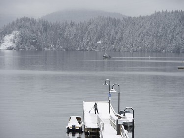 A man shovels the snow off the government dock in Deep Cove in North Vancouver, B.C., Friday, Feb. 3, 2017. A snowstorm hit the northshore leaving cars and trucks slipping and sliding.