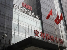 A worker cleans windows of the Anbang Insurance Group's building in Beijing, China.