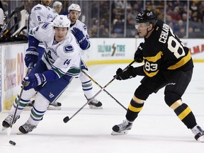 Vancouver Canucks' Alexandre Burrows (14) brings the puck up against Boston Bruins' Peter Cehlarik (83), of Slovakia, during the first period of an NHL hockey game in Boston, Saturday, Feb. 11, 2017. The Bruins won 4-3.