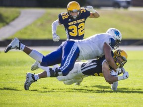 Dontae Bull tackles a South Delta Sun Devils player during a high school football game at South Delta Secondary School in Delta, BC., September 24, 2016.