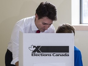 Justin Trudeau carries his vote to the ballot box accompanied by his son Xavier on October 19, 2015 in Montreal.