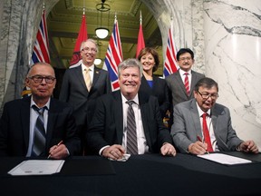 Chief Councillor Harold Leighton (front row, left to right), Minister Rich Coleman and Mayor John Helin, and back row, left to right, Minister John Rustad, Premier Christy Clark, and Pacific NorthWest LNG chief project officer Wan Badrul are shown during the signing of documents as the province of B.C. and Lax Kw'alaams Band reached multiple agreements with First Nations to announce the construction and operation of a liquefied natural gas export industry in Prince Rupert during a press conference in the Legislative Library on Wednesday, February 15, 2017 in Victoria, B.C.