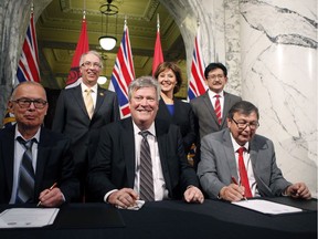 (Front row, from left) Chief Coun. Harold Leighton, Minister Rich Coleman and Mayor John Helin, and (back row, from left), Minister John Rustad, Premier Christy Clark and Pacific NorthWest LNG project officer Wan Badrul during the signing between the parties and Lax Kw'alaams of multiple deals for the construction-operation of a liquefied natural-gas industry in Prince Rupert at the legislature library on Feb. 15 in Victoria.