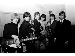 Dec. 1, 1965. The Rolling Stones backstage before their first Vancouver concert at the Agrodome. From left, Brian Jones, Keith Richards, Mick Jagger, an unidentified woman, Bill Wyman and Charlie Watts.