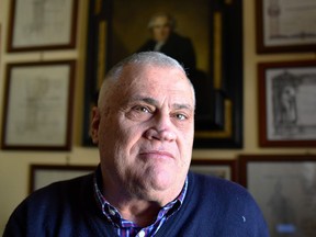 Luciano Baietti, who has been awarded 'The more graduated man in the world' by the Guinness Book of World Records, poses under some of his university degrees in his house in Velletri, south of Rome, on Feb. 7. Baietti, 70, a former school administrator and professor of physical education, received his 15th university degree, this time in tourism sciences.