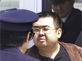 This May 4, 2001, file photo shows Kim Jong-nam, exiled half-brother of North Korea's leader, Kim Jong-un, escorted by Japanese police at the airport in Narita. Jong-nam told medical workers before he died Feb. 13, 2017, that he had been attacked at a Malaysian airport with a chemical spray, according to Malaysian officials.