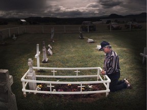 A man prays at the gravesite of Rose Prince at Lejac, west of Prince George.