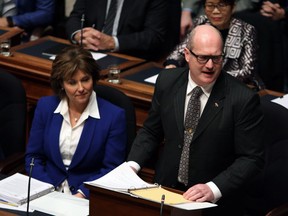 Premier Christy Clark looks on as B.C. Finance Minister Mike de Jong delivers provincial budget Feb. 21, 2017.