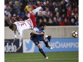New York Red Bulls midfielder Gonzalo Veron (30) and Vancouver Whitecaps midfielder Russell Teibert collide while competing for the ball during the second half of a CONCACAF Champions League quarterfinal soccer match, Wednesday, Feb. 22, 2017, in Harrison, N.J.