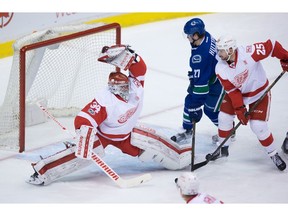 Petr Mrazek makes a glove save as  Ben Hutton and Mike Green look on.