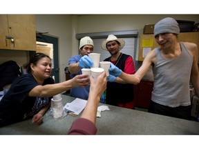 Program participants toast cups of beer they made at the Portland Hotel Society alcohol-brewing co-op program in Vancouver in 2014.