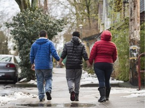 A family from Honduras who recently arrived, crossing through the snow, walk along a street this week in Vancouver.