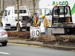 Crews check over a smashed vehicle, which jumped the landscaped road divider and crashed into on oncoming truck just north of Lions Bay. The media is being replaced with a standard freeway concrete barrier to prevent such crossover accidents.