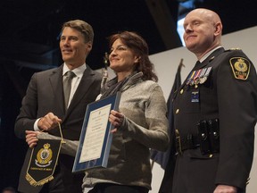 Penny Szekely is presented an Award of Merit by Vancouver Mayor Gregor Robertson and Chief Constable Adam Palmer for helping save nine people from a rooming house fire on Feb. 23, 2016.