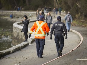 Vancouver park rangers patrol the Stanley Park seawall on Saturday.