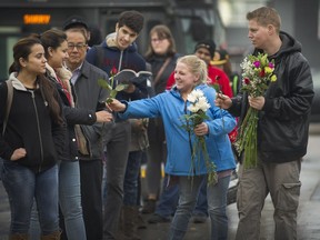 Rhiannon Paskall and her partner Jonah hand out flowers to strangers at the Newton bus exchange, as a random act of kindness, in Surrey last week. Rhiannon, whose mother Julie Paskall was killed after a December 2013 assault, is part of a grassroots group to make the area safer.