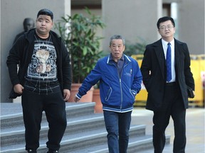 Cang Sun, centre, father of North Vancouver slaying victim Peng Sun, outside court in Vancouver Tuesday with another relative and a Chinese consular official, right. Tian Yi Eddie Zhang was sentenced to 14 years in prison for extortion and manslaughter.